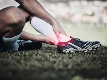 Injury, soccer and a man on a field with foot pain, training accident and medical emergency at a game. Inflammation, football and a male athlete with a leg or anatomy problem during sport on grass.